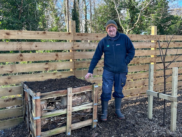 Photo of Tim Hewer next to a newly built bug hotel