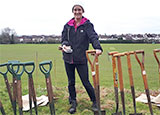 Photo of a volunteer holding a spade ready for tree planting