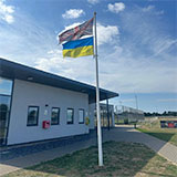 Photo of the Union Jack and Ukrainian Flag flying outside Little Stoke Community Hall