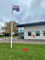 Photo of Little Stoke Community Centre with flag and poppy