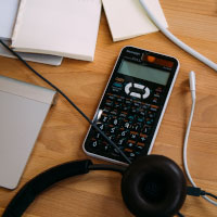 Photo of a calculator on a desk with paperwork